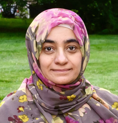 Portrait of Dr. Aaila Chaudhry wearing a floral patterned hijab, standing outdoors with greenery in the background, representing professionalism and compassionate care – IC Laser Eye