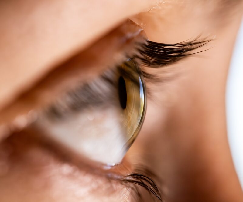 Extreme close-up of a human eye with visible eyelashes and natural skin texture, symbolizing the delicate healing process and recovery timeline associated with upper eyelid surgery – Upper Eyelid Surgery Healing Time