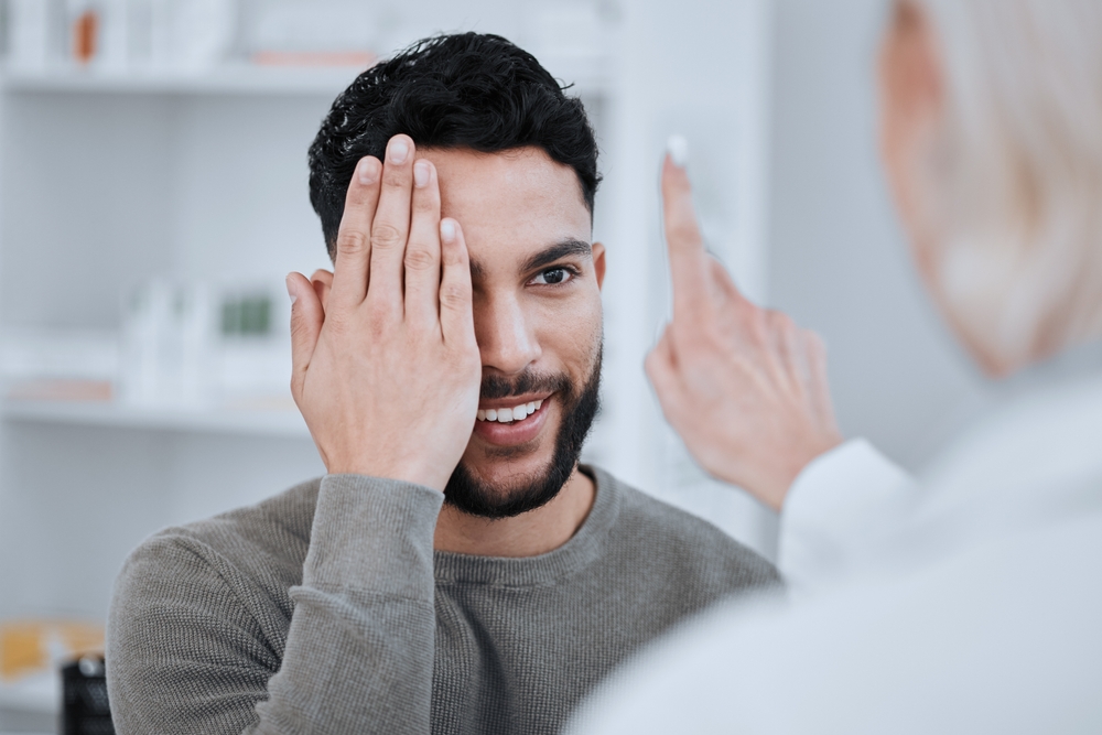 A man covering one eye during a vision test, highlighting professional eye exams and LASIK candidacy evaluation - LASIK eye surgery Philadelphia
