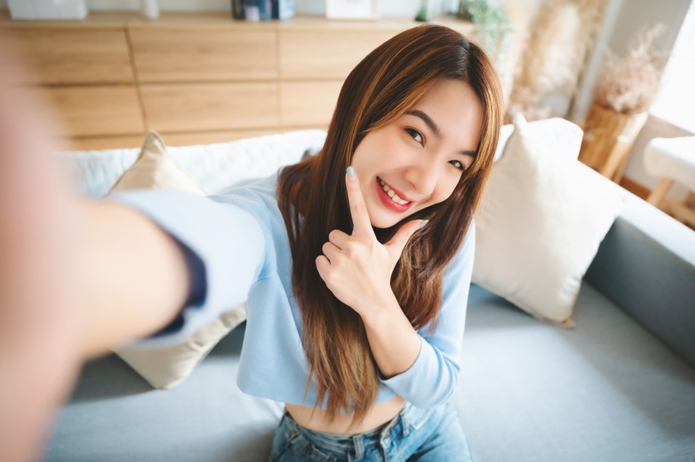 A confident woman smiling for a selfie, symbolizing clear vision and enhanced lifestyle after LASIK treatment - LASIK eye surgery Philadelphia